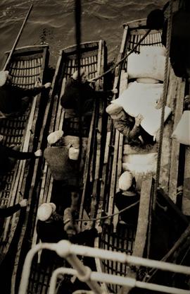 Aran Islanders loading supplies onto currachs